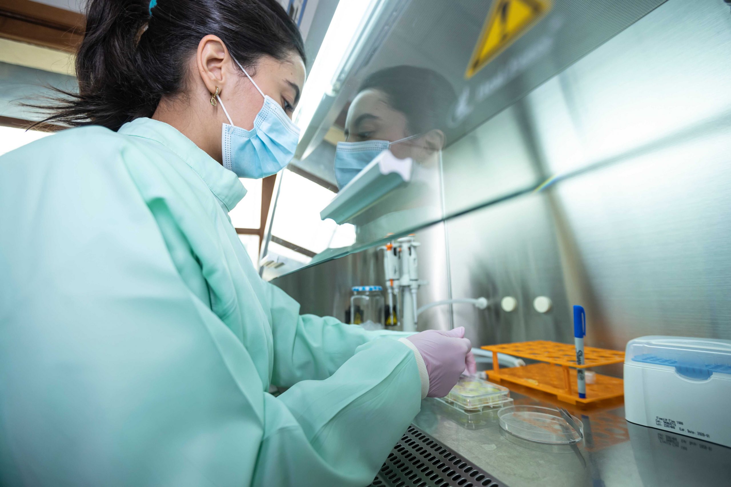 Fotografía de una estudiante de doctorado tomando muestras en el laboratorio institucional del campus Los Leones